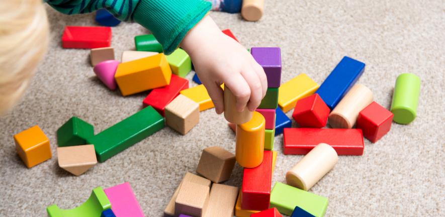 Baby playing with wooden construction toys